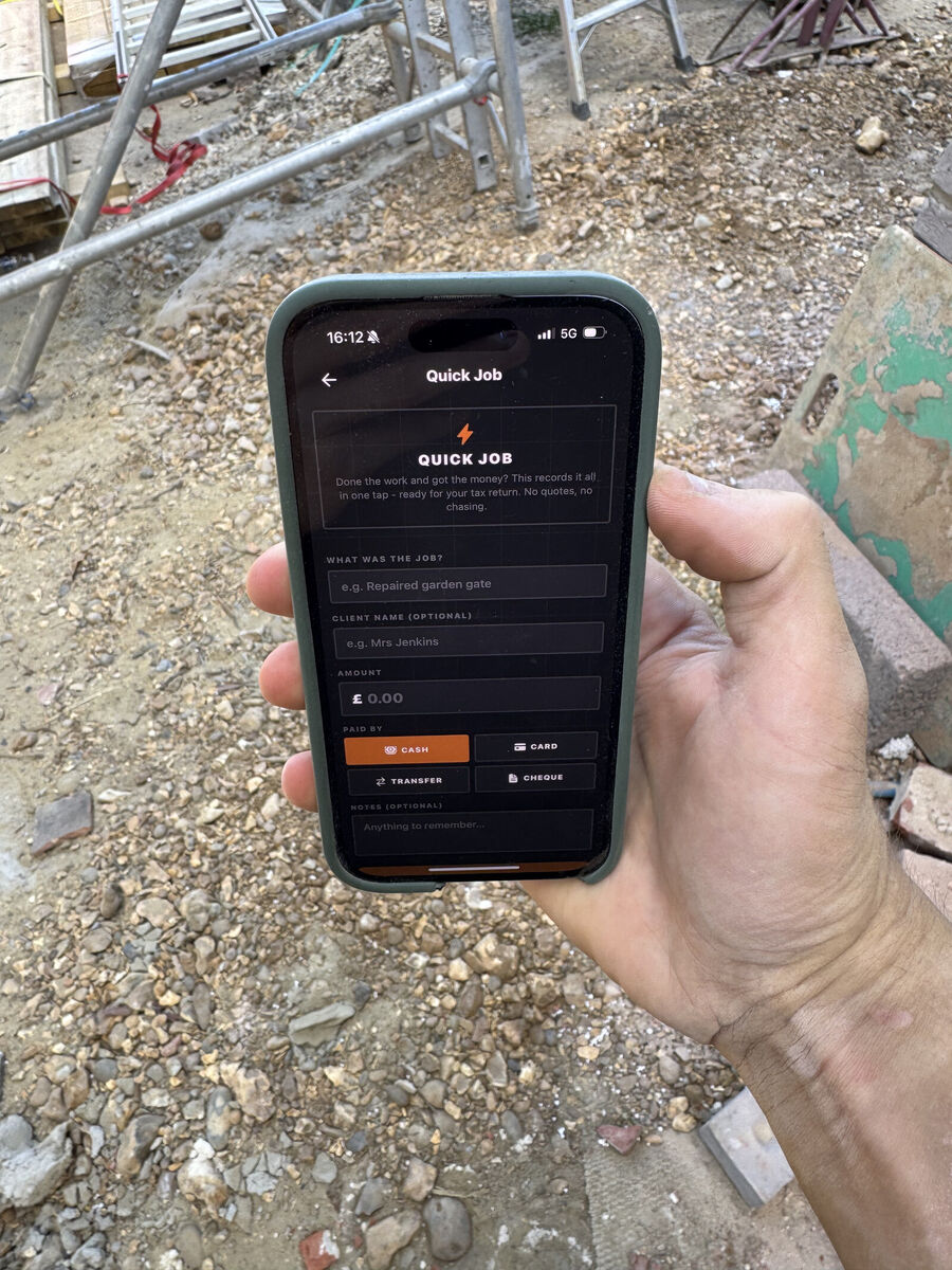 A tradesperson standing on a building site logging a finished job in the Graft app